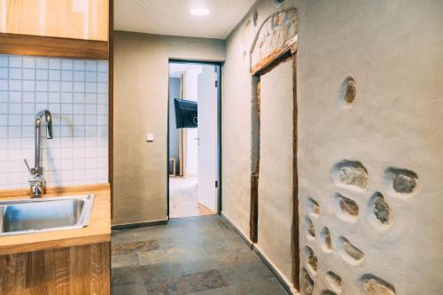 una cucina con una porta aperta e un lavandino di Amtshaus Gut Hügle Boutique Apartments a Bad Waldsee