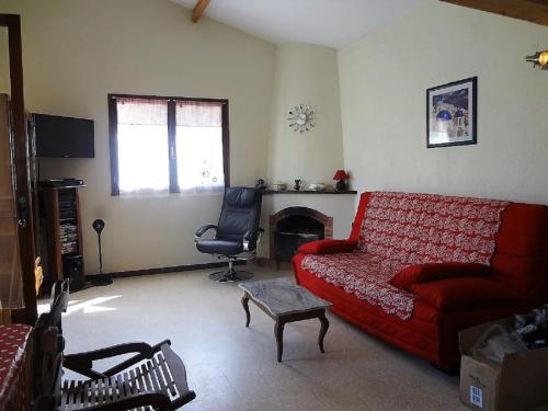 sala de estar con sofá rojo y silla en Cottage provençal, en Belgentier