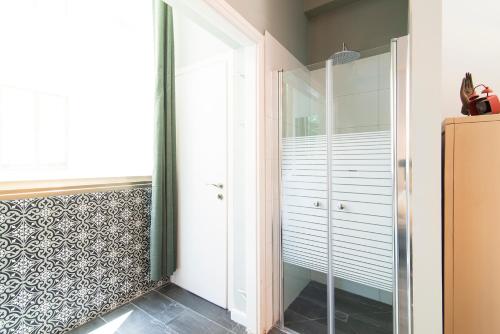 a walk in shower in a bathroom with a glass door at Talent Boutique by TLV2rent in Tel Aviv