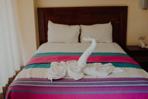 a bed with two swans made out of towels at Hotel Ambassador Mérida in Mérida