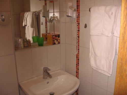 a bathroom with a sink and a toilet and towels at Pension Haus Ursula in Koblenz