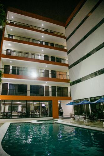 a swimming pool in front of a building at Hotel Ambassador Mérida in Mérida