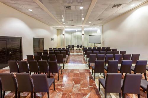 an empty room with chairs and a screen at Catalonia Punta Cana - All Inclusive in Punta Cana