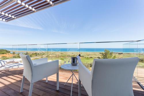 a patio with white chairs and a table and a view of the ocean at Palmares Beach House Hotel - Adults Friendly in Lagos