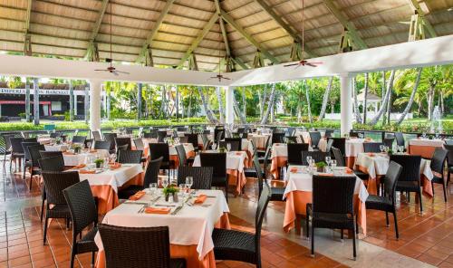 a restaurant with white tables and chairs and a large ceiling at Catalonia Punta Cana - All Inclusive in Punta Cana