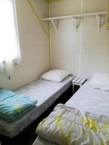 une chambre avec deux lits et une fenêtre dans l'établissement camping Le Kermadec, à Ambon