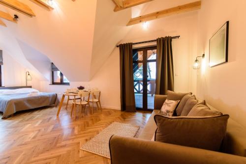 a living room with a couch and a bed and a table at Apartamenty Rydzewo in Rydzewo