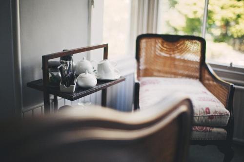 a room with a chair and a table and a window at Rum Doodle, Windermere B&B in Windermere