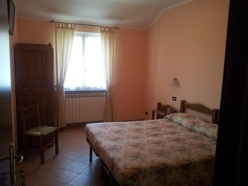 a small bedroom with a bed and a window at Agriturismo Bell'Aria in Uscio