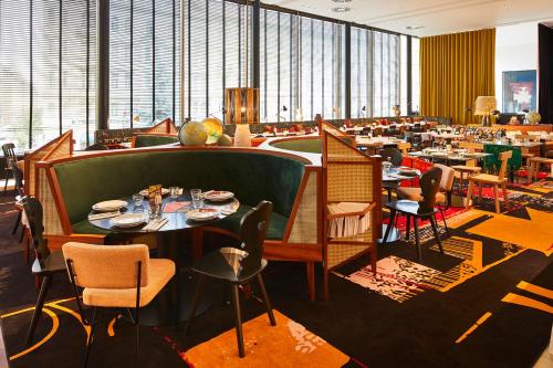a dining room with tables and chairs in a restaurant at Mama Shelter Prague in Prague