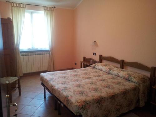a bedroom with a bed and a window at Locanda Bell'Aria in Uscio