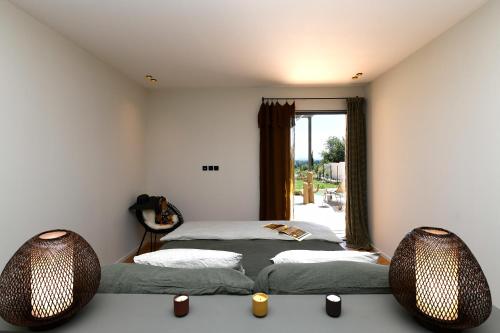 ヴィルヌーヴ・レ・ザヴィニョンにあるLes Loges En Provence "Villa Garrigue"のベッドルーム1室(ベッド2台、窓付)