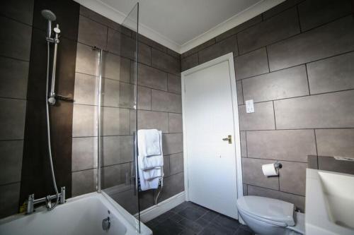 a bathroom with a sink, toilet and bathtub at Faenol Fawr Country Hotel in Bodelwyddan