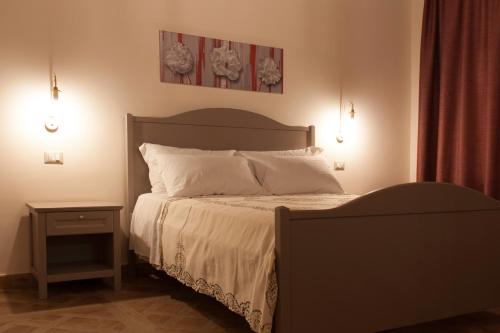a bedroom with a bed and a nightstand with a bed sidx sidx sidx sidx at Case Vacanze Al Duomo in Licata