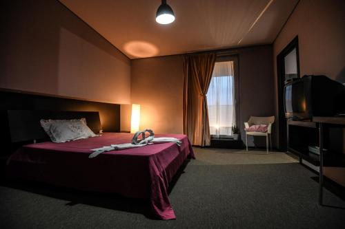 a hotel room with a bed and a tv at La Torre-1984 in Sarnelli