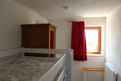 a bedroom with a bed with a red curtain and a window at Fritsch Häusel in Neustadt an der Weinstraße