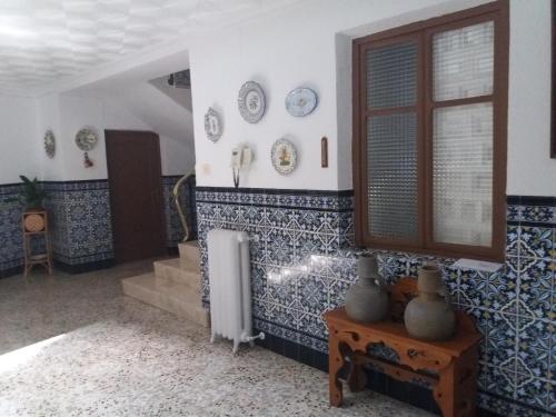 a room with blue and white tiled walls and a window at Casa Labradora in Herencia