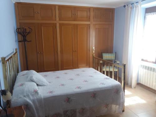 1 dormitorio con 1 cama y armario de madera en Casa Labradora, en Herencia