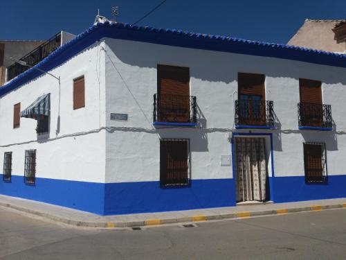 a blue and white building with windows on a street at Casa Labradora in Herencia