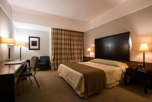 Un pat sau paturi într-o cameră la FlyOn Hotel & Conference Center