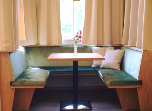 a table and two benches in a room with a window at Hotel Jarolim in Bressanone