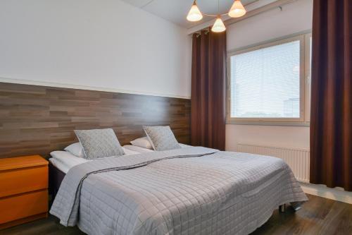 ein Schlafzimmer mit großem Bett und Fenster in der Unterkunft Torget Apartment Laululinna in Pori