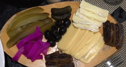 a plate of cheese and vegetables on a cutting board at Jamaica Palace Hotel in Port Antonio
