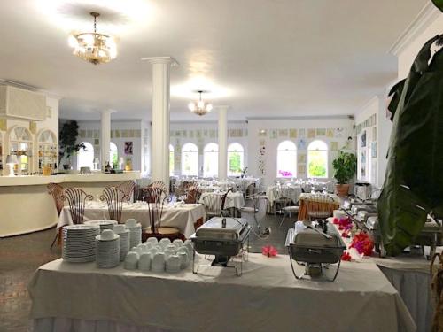 a large room with tables and chairs in a restaurant at Jamaica Palace Hotel in Port Antonio