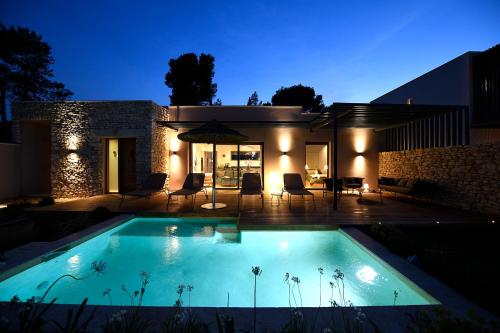 une piscine devant une maison la nuit dans l'établissement Les Loges En Provence 