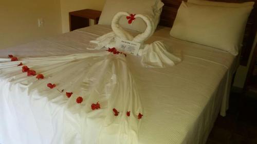a white bed with a swan made out of roses at Pousada Berro do Jeguy in Pipa