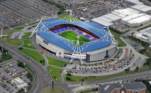 a large blue and white soccer field with a stadium at Bolton Whites Hotel in Bolton