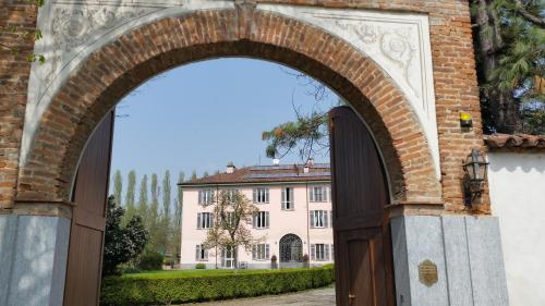 an archway leading to a large white building at B&B La Cascina Grossa in Alessandria