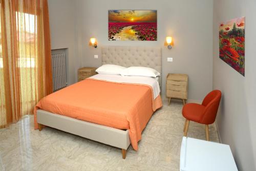 een slaapkamer met een bed en een rode stoel bij B&B L’Angolino in Montesilvano