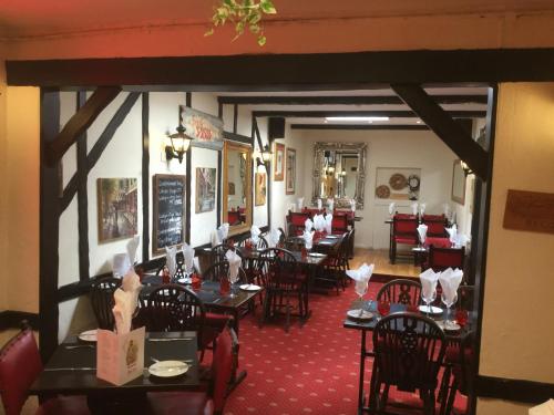 uma sala de jantar com mesas e cadeiras num restaurante em The Captains em St Martin Guernsey