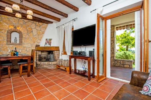 ein Wohnzimmer mit einem Steinkamin und einem TV in der Unterkunft Monte Holiday Home with Jacuzzi in Rovinj