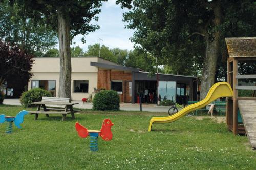 a playground with colorful play equipment in the grass at Camping Listro in Castiglione del Lago