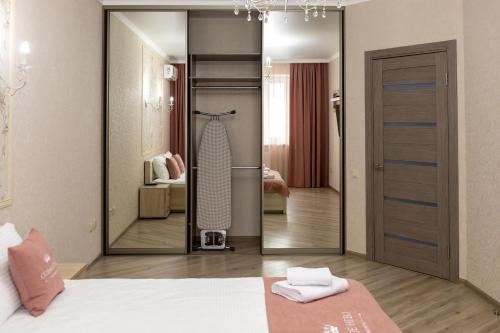 a bedroom with a closet with a mirror and a bed at Apartment Seventh Sky - Cream in Krasnodar