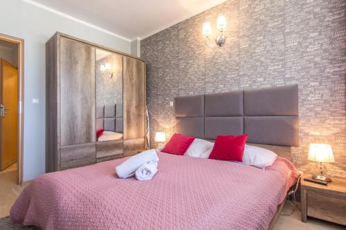 1 dormitorio con 1 cama grande con almohadas rojas y blancas en Apartamenty Viva Maria Zakopane, en Zakopane