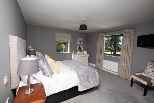 a bedroom with a bed with a lamp and a chair at Inch View Lodge in Milltown