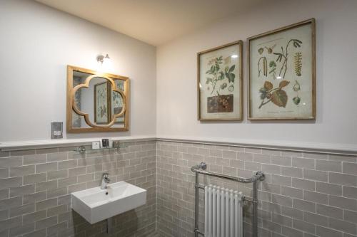 a bathroom with a sink and two pictures on the wall at The Frogmill Hotel in Cheltenham