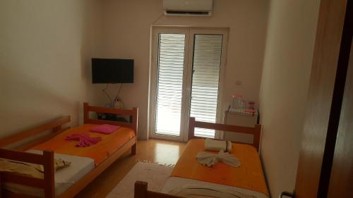 two beds in a small room with a window at Room With Sea View in Kotor