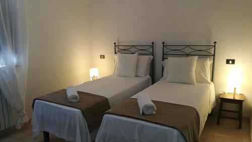 1 dormitorio con 2 camas y toallas. en LAE' affittacamere, en Roccamontepiano
