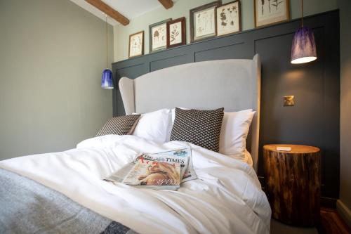 a bedroom with a bed with a newspaper on it at The Frogmill Hotel in Cheltenham