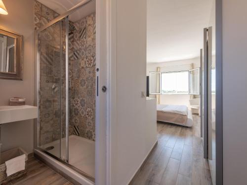 a bathroom with a shower and a bedroom at Panoramic Studio Carloforte in Carloforte