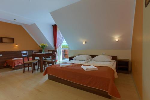 Una habitación de hotel con una cama y un comedor. en Pensjonat Willa Szarotka, en Kluszkowce