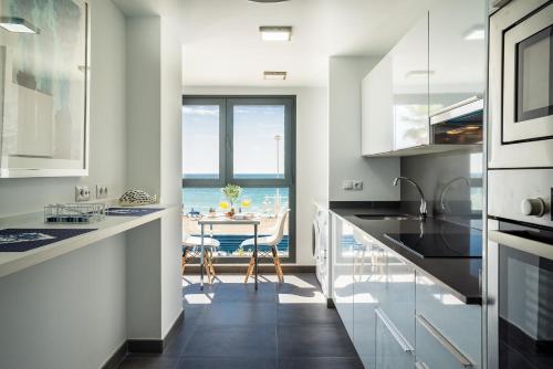 a kitchen with a table and a view of the ocean at Gran vivienda de lujo frente al mar in Málaga