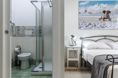 ein Schlafzimmer mit einem Bett und ein Badezimmer mit einer Dusche in der Unterkunft B&B Villa Ida Pescara Centro in Pescara