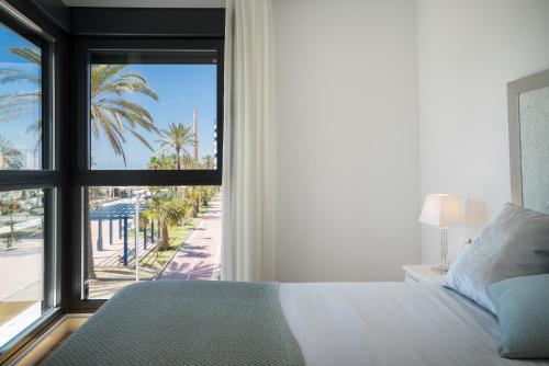 ein Schlafzimmer mit einem Bett und einem Fenster mit Aussicht in der Unterkunft Gran vivienda de lujo frente al mar in Málaga