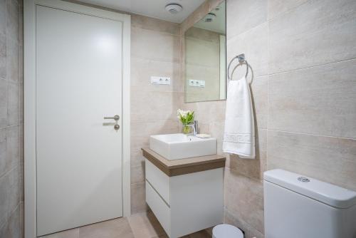 ein Badezimmer mit Waschbecken, Toilette und Spiegel in der Unterkunft Gran vivienda de lujo frente al mar in Málaga