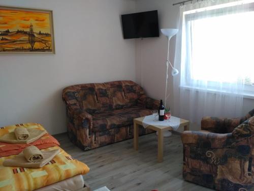 a living room with a couch and a chair at Apartmán v Zátiší in Staré Splavy